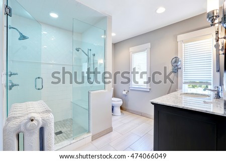 Refreshing bathroom with large glass walk in shower with two heads and cast-iron radiator in retro style. Northwest, USA
