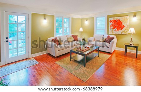 Green living room with white sofa and beautiful hardwood floor.