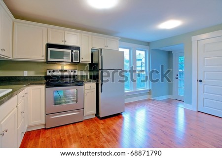 White modern empty kitchen with stainless still appliances.