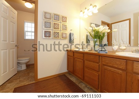Bathroom with light walls and wood cabinet