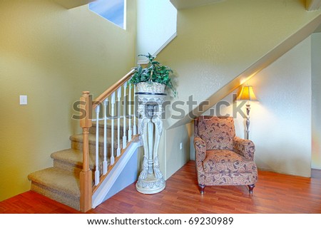 Hallway, entrance with staircase and large chair.