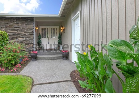 Front door and walkway of the brown rambler house