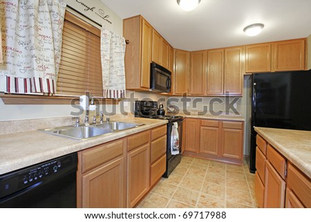 Light wood kitchen with black appliances