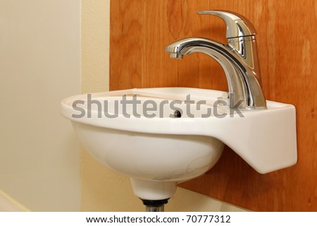 Small sink with wood panel and yellow wall
