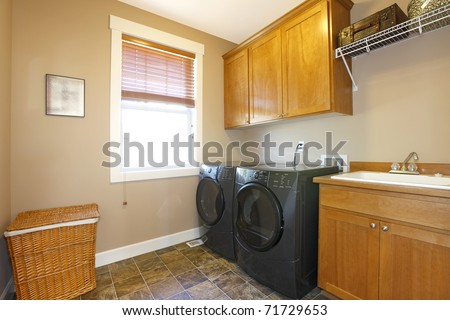 Laundry room with black appliances and nice cabinets