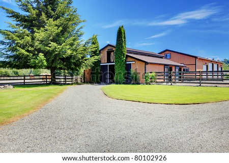 Barn and Pasture ground at the horse ranch in Washington State, USA with the wood fence and the houses in the background.