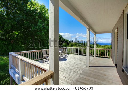 Summer deck of the grey house with railings.