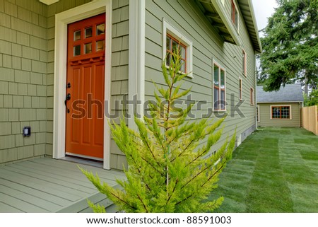Front orange door of the green house .