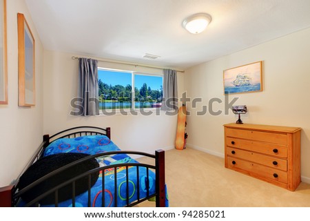 Small simple bedroom with blue bed and dresser.