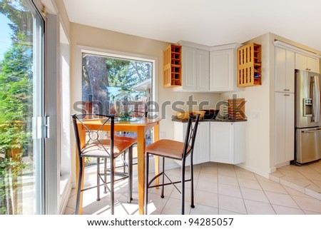 Bright white room near kitchen with small breakfast table.