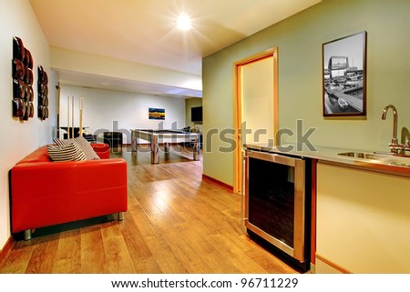 Fun play room home interior. Basement room without windows with pool table, TV, games.