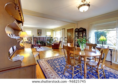 Old country English charm living and dining room with blue rug.