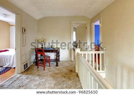 Home interior with old writing desk with red chair.