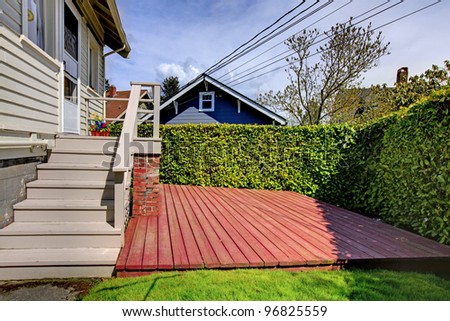 Small simple house with a small back yard deck.