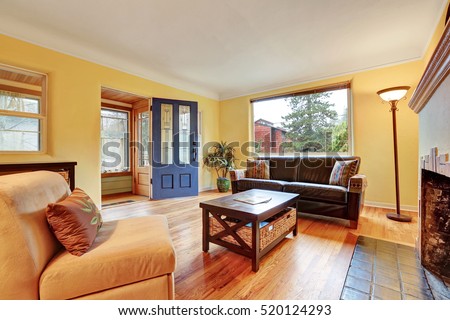 Cozy living room interior with warm yellow walls , fireplace and hardwood floor. Northwest, USA