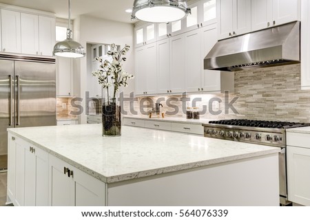 Gourmet kitchen features white shaker cabinets with marble countertops, stone subway tile backsplash, double door stainless steel refrigerator and gorgeous kitchen island. Northwest, USA