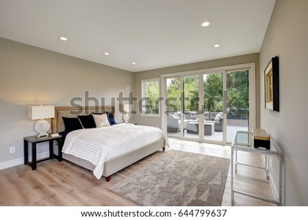 Master bedroom interior with private balcony in a new construction home. Northwest, USA