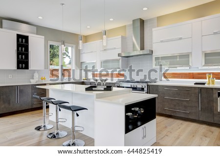 Luxury kitchen with  natural backsplash, white quartz, natural brown wood cabinets and lots of light. Northwest, USA
