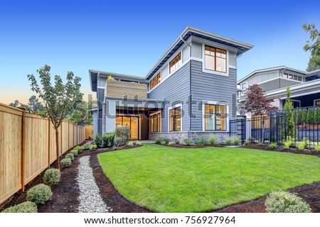 Exterior of grey blue craftsman style home with Welcoming backyard and covered patio. Northwest, USA