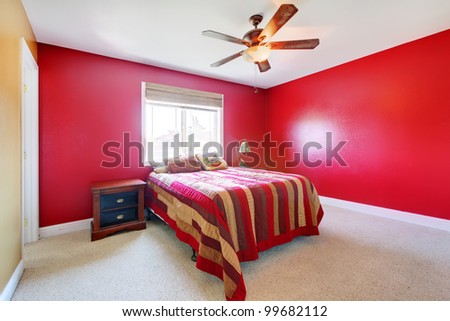 Simple red bedroom with bed and nightstand.
