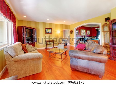 Beautiful gold living room with cherry hardwood floor and red.