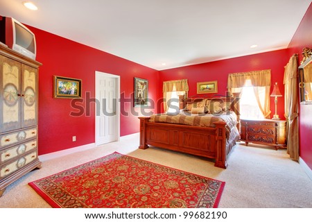 Large red bedroom with old bed and two windows.