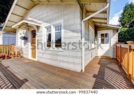 Simple small grey and white house and deck.