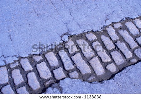 Cracked road and cobbles stained blue.