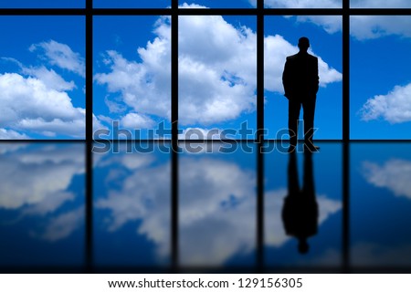 Business Man Looking Out Of High Rise Office Window At Blue Sky And Clouds