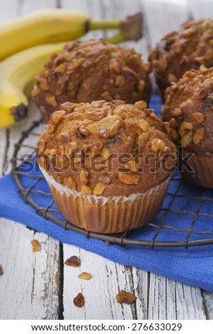 Fresh baked banana nut muffins with walnuts on a rustic wooden table