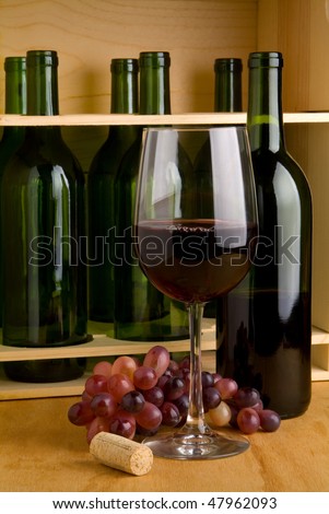 A case of red wine bottles with glass and grapes