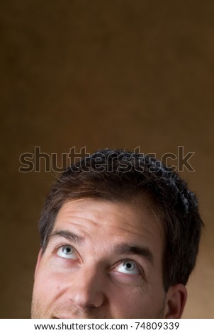 Close up of a young mans face looking up into empty type space