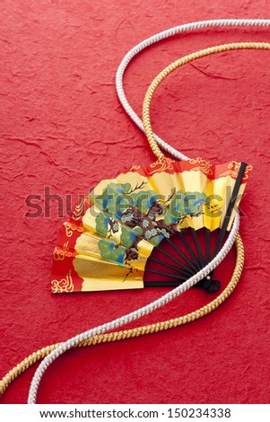 golden beautiful fan and string,on red japanese paper