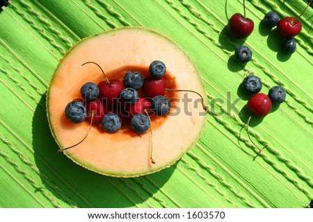 fruits are on the bright green table-mat under sunlight