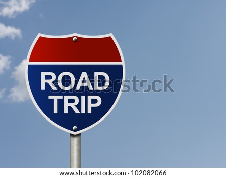 An American interstate road sign with words Road Trip over a sky background, Taking a road trip