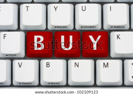A computer keyboard with red keys spelling buy, Buying on the internet