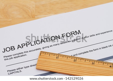 A job application form with a ruler on a wooden desk, How you measure up when applying for a job
