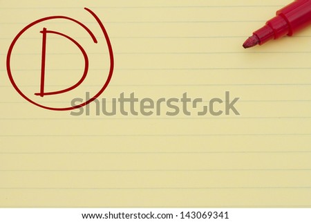 Yellow Lined Paper with the grade D in red circled and a marker, Getting a poor grade