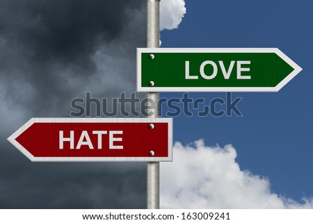 Red and green street signs with blue and stormy sky with words Love and Hate, Love versus Hate