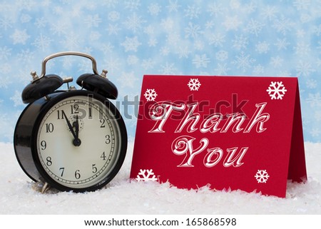 An old-fashion alarm clock with a Thank You red card on snow and a blue snowflake background, Christmas is a Time to be Thankful