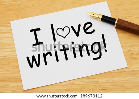 I love writing, A white card with text of I love writing and a fountain pen on a wooden desk