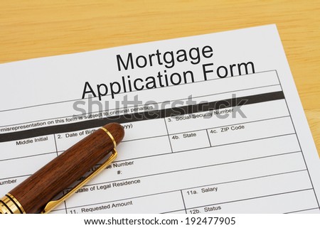 Mortgage Application Form with a pen on a wooden desk
