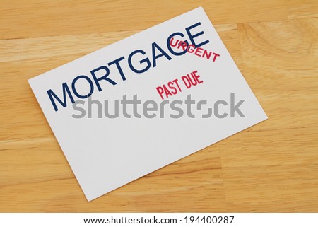 Mortgage Payment envelop with past due and urgent stamps on a wooden desk