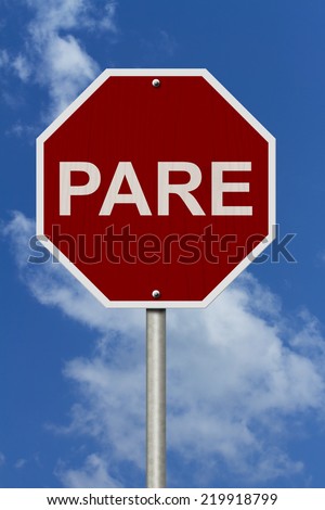 Pare Sign, An red stop sign with Spanish word for stop Pare with sky background