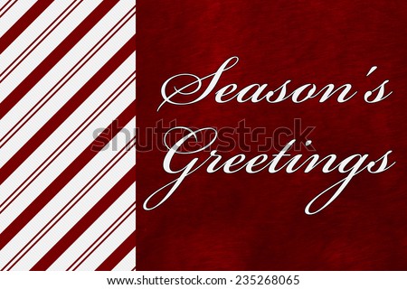 A Season\'s Greetings card, A Candy Cane Stripes with words Season\'s Greetings over red plush background