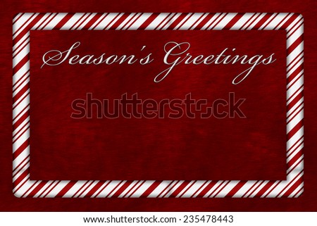A Season\'s Greetings card, A Candy Cane border with words Season\'s Greetings over red plush background with copy-space