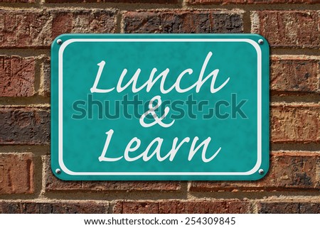 Lunch and Learn Sign,  A teal sign with the word Lunch and Learn on a brick wall