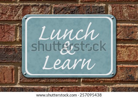 Lunch and Learn Sign,  A blue sign with the word Lunch and Learn on a brick wall