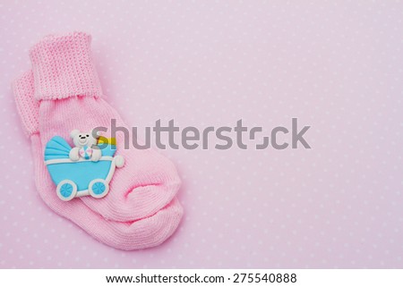 Pink Baby Background, Pink baby socks with baby toy on pink and white polka dot background with copy-space for your message