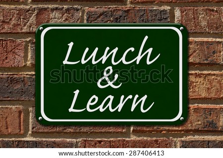 Lunch and Learn Sign,  A green sign with the word Lunch and Learn on a brick wall